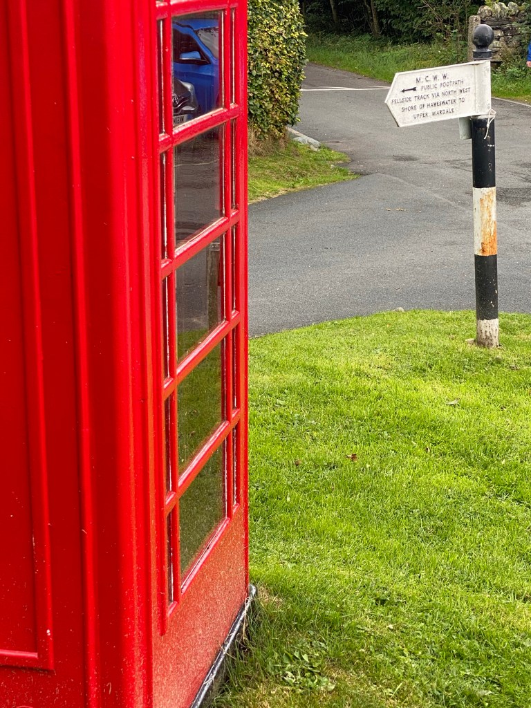 red phone box and signpost