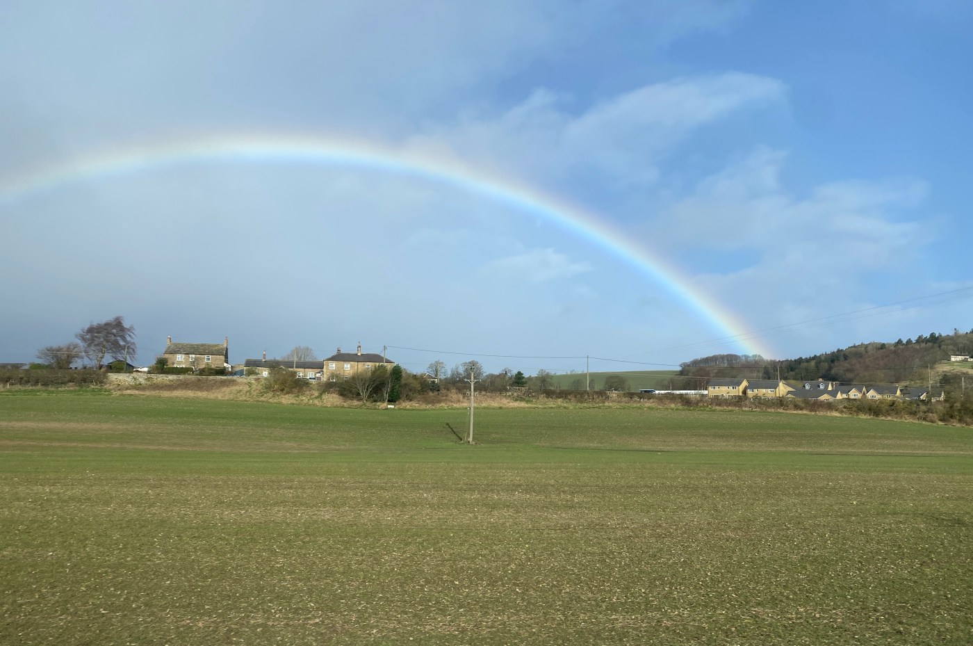 A rainbow over a field of green