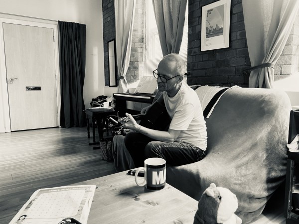 Man playing guitar by table